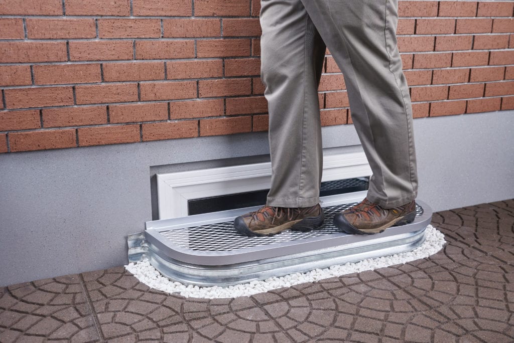 Person standing on an AIL Window Well’s Safety Cover