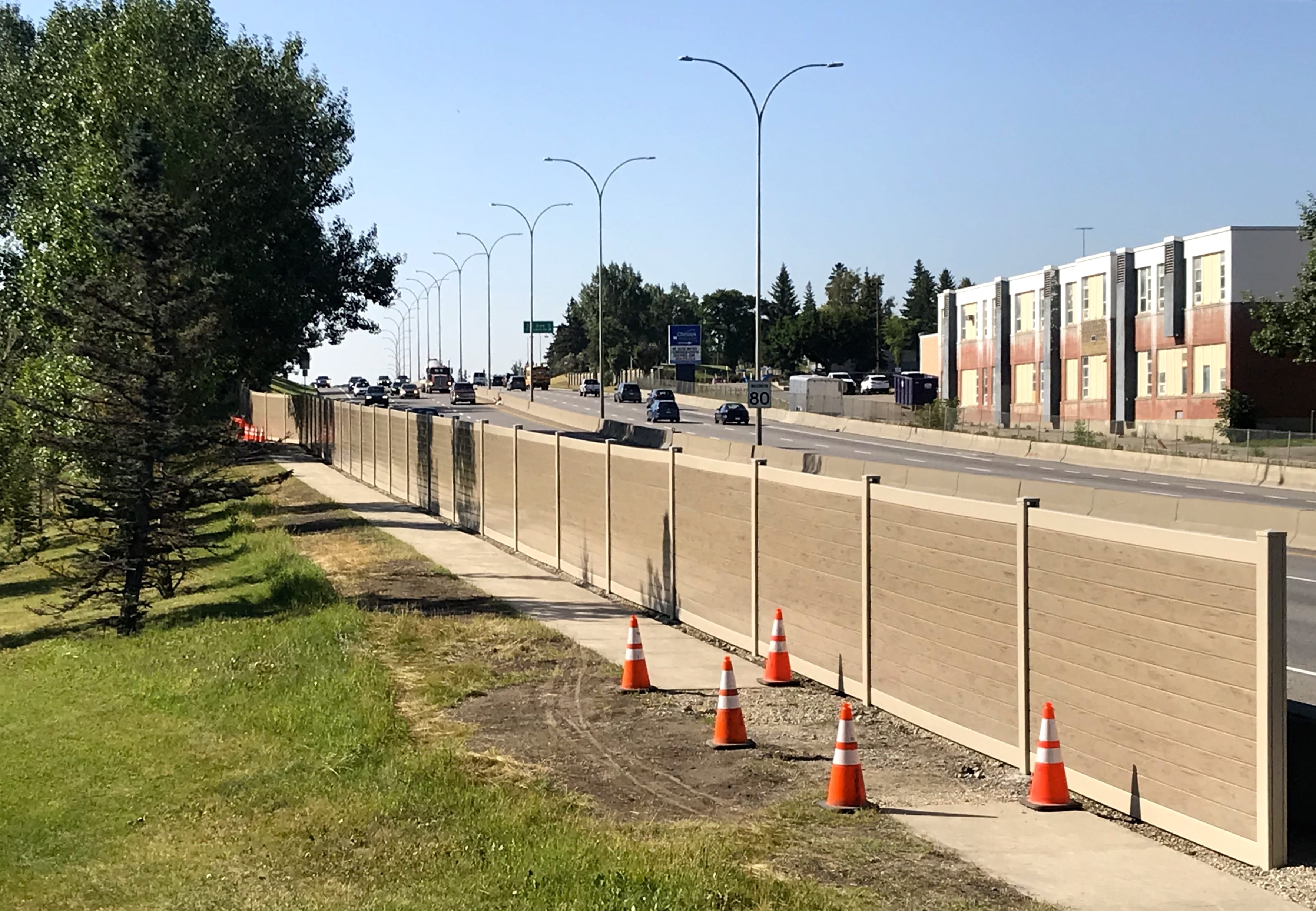 Wider sidewalk view of Calgary highway sound barrier wall