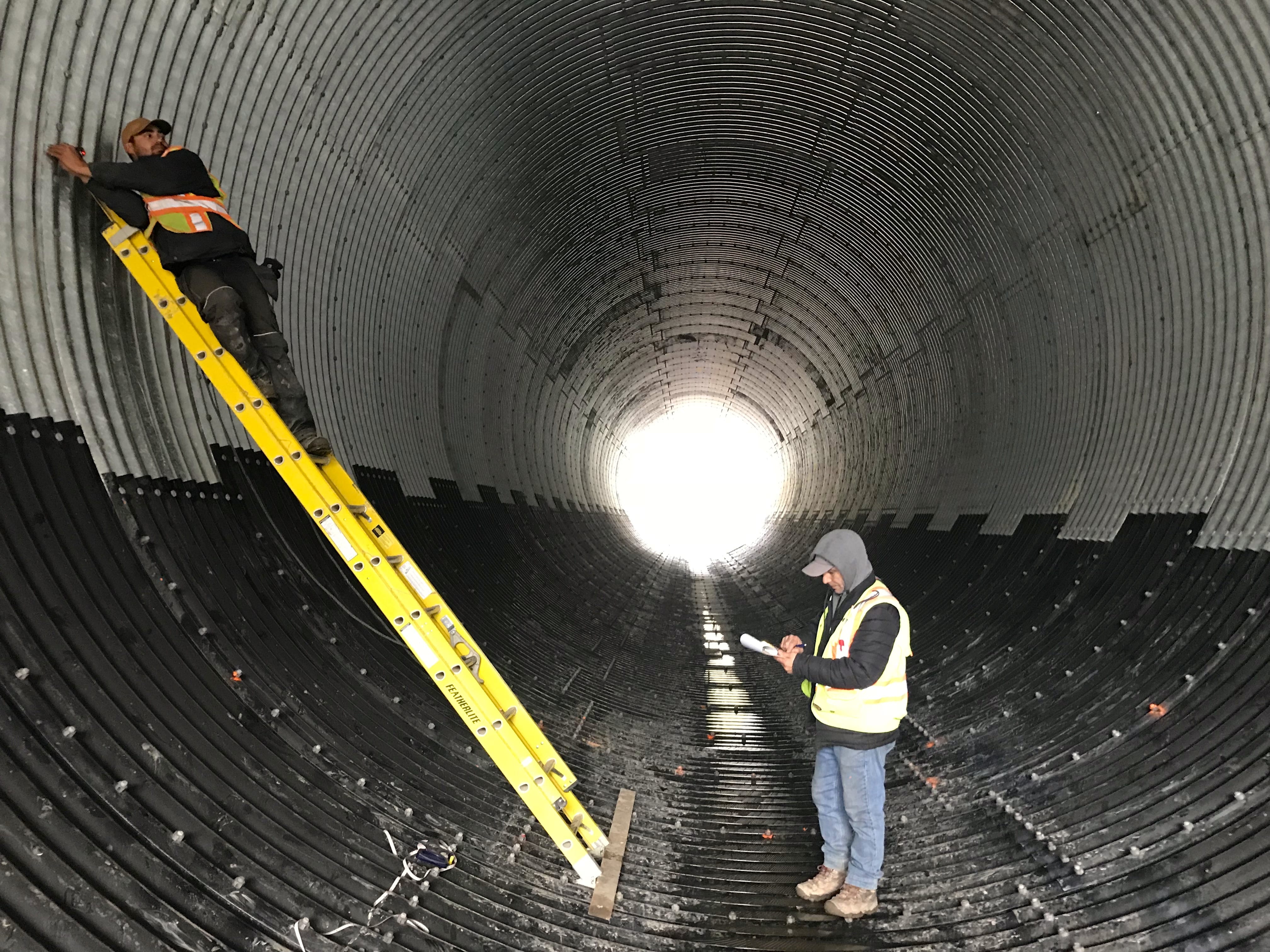 : Interior view of technicians monitoring partially-coated Bolt-A-Plate culvert