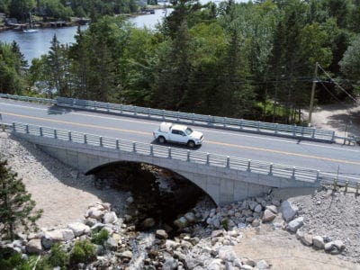 Buried arch bridge with precast panel headwall