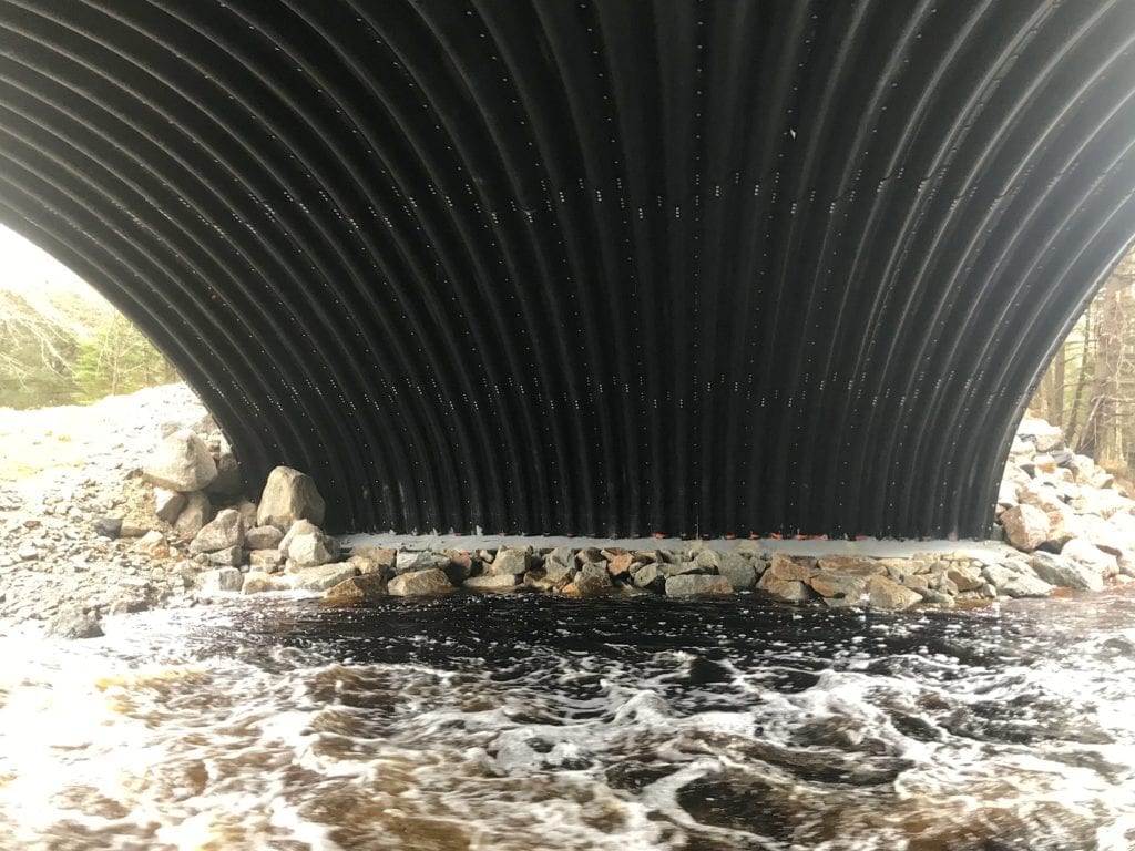 Buried arch bridge footing with scour protection
