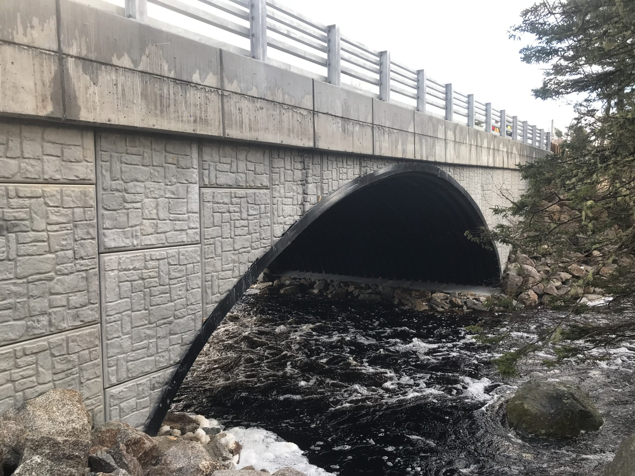 Buried arch bridge with precast panel headwall