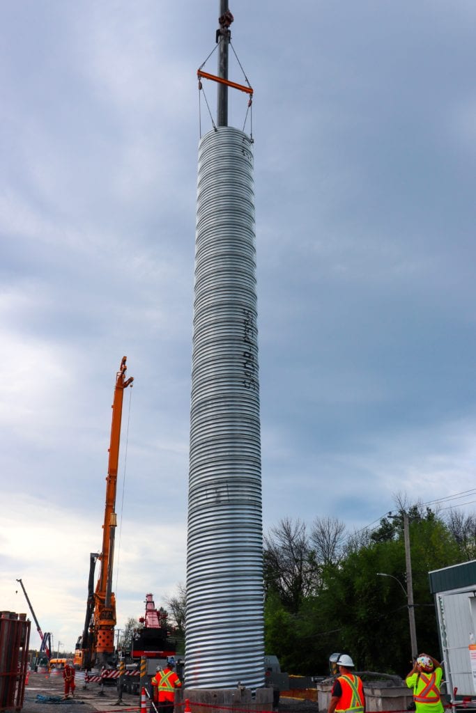 Corrugated Steel Pipe lowered into footing cavity