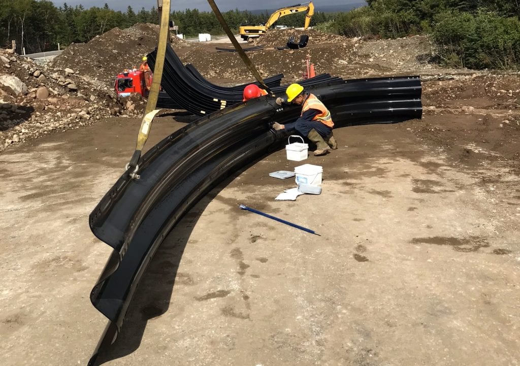 Workers assembling first section of box culvert