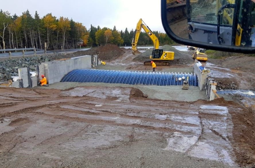 Backfilling continues on buried metal bridge