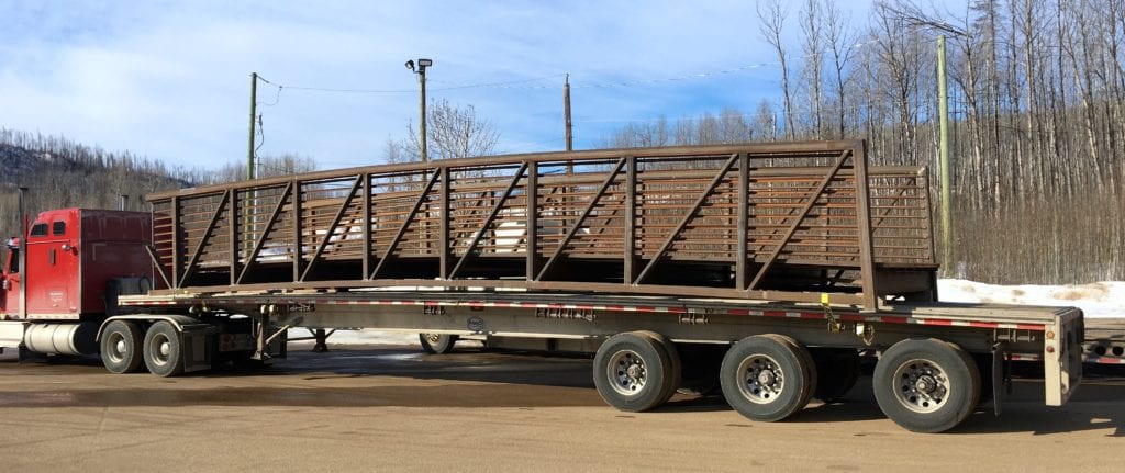 One section of golf-course bridge arrives on flatbed trailer