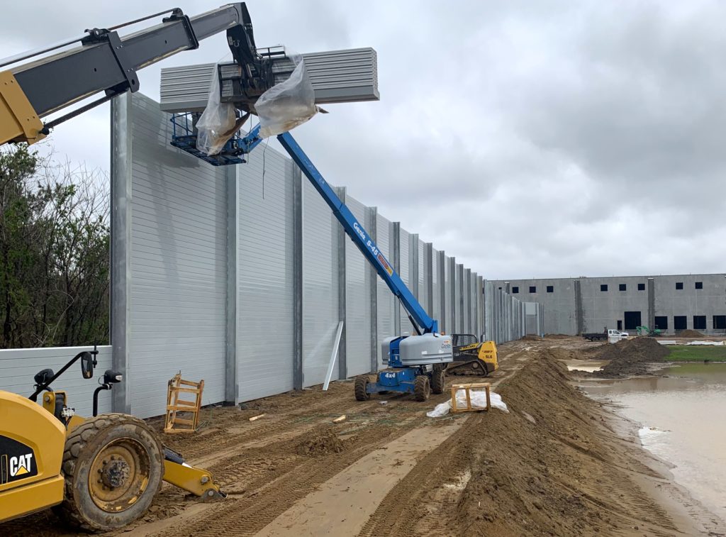 Installing sound barrier wall panels with boom trucks