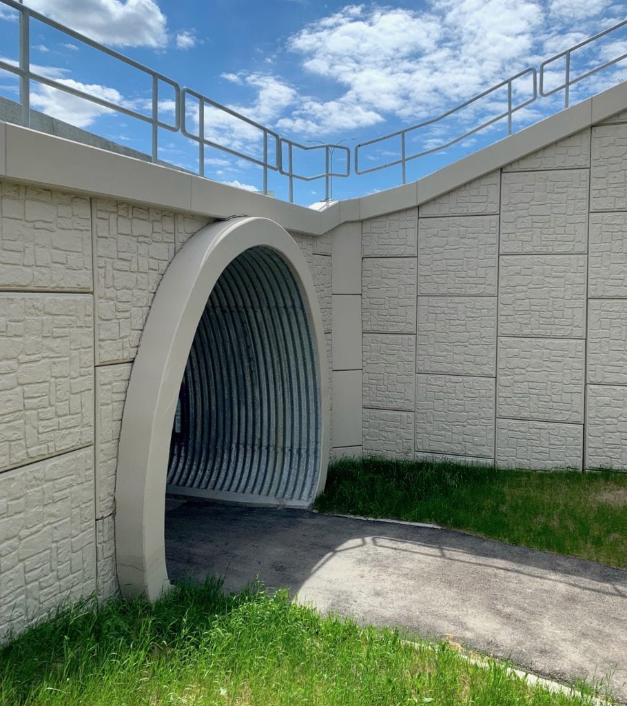 Trail-level view of buried metal pedestrian tunnel