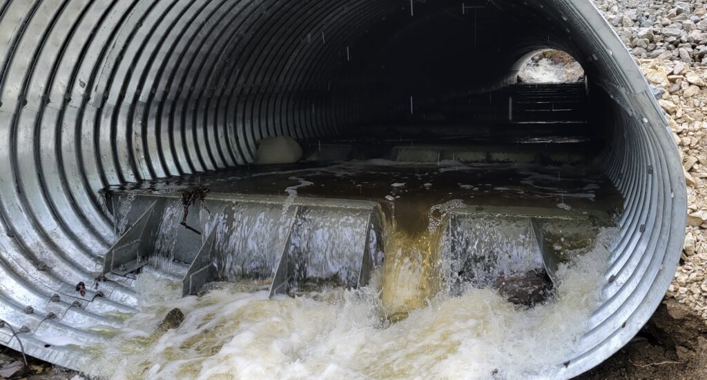 Water flowing through fish baffles in pipe arch culvert