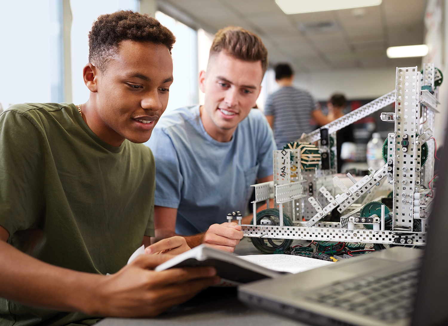 Students with textbooks learning robotics