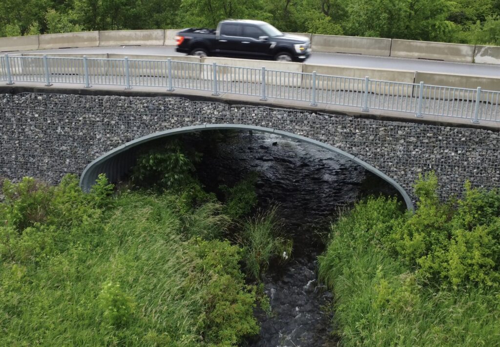Structural plate buried bridge with open fish passage and hydraulic flow