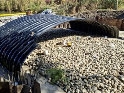 Wide construction view of buried metal bridge stream crossing