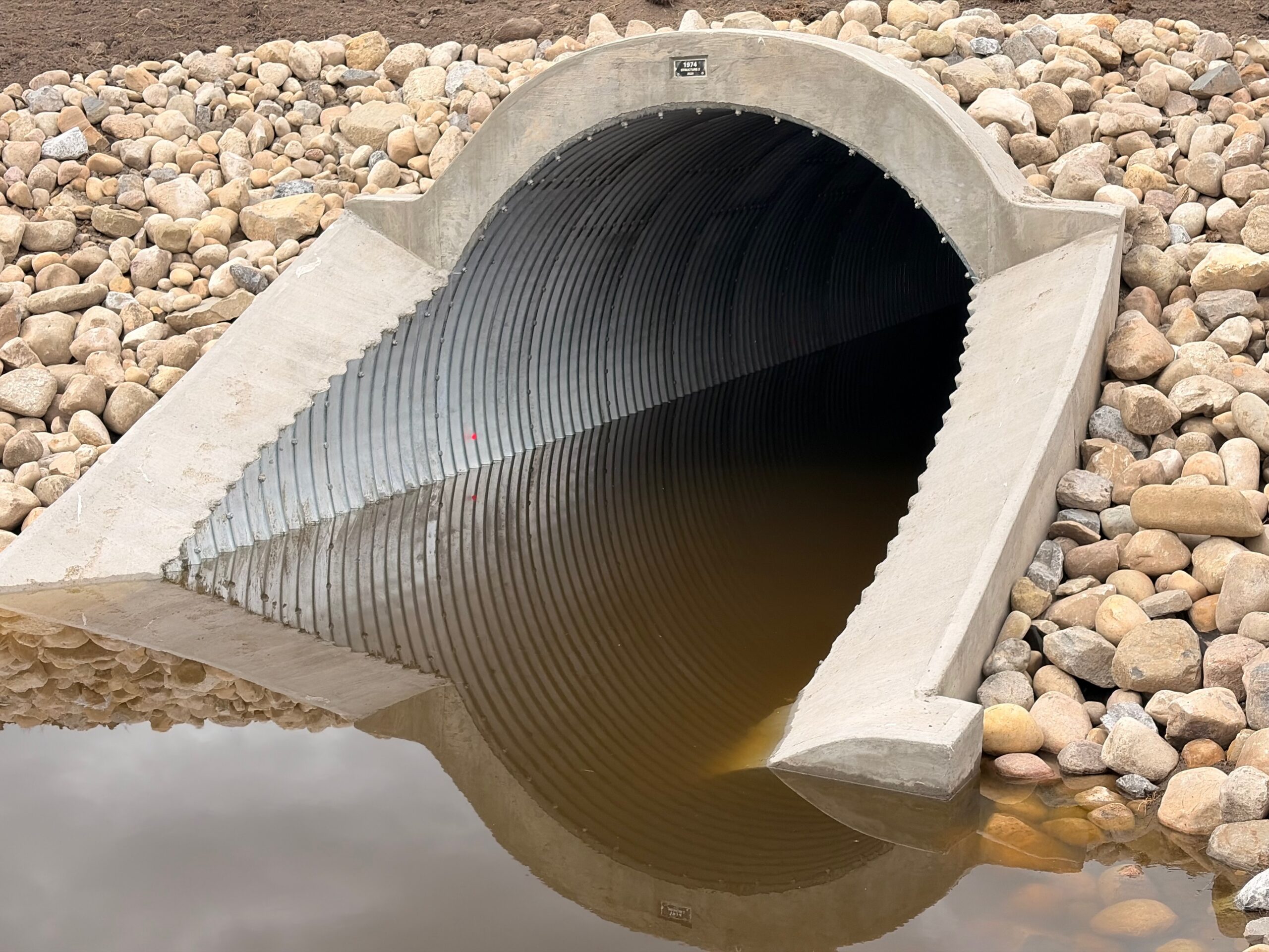 Angled view of AIL Bolt-A-Plate steel plate culvert with step-bevel ends