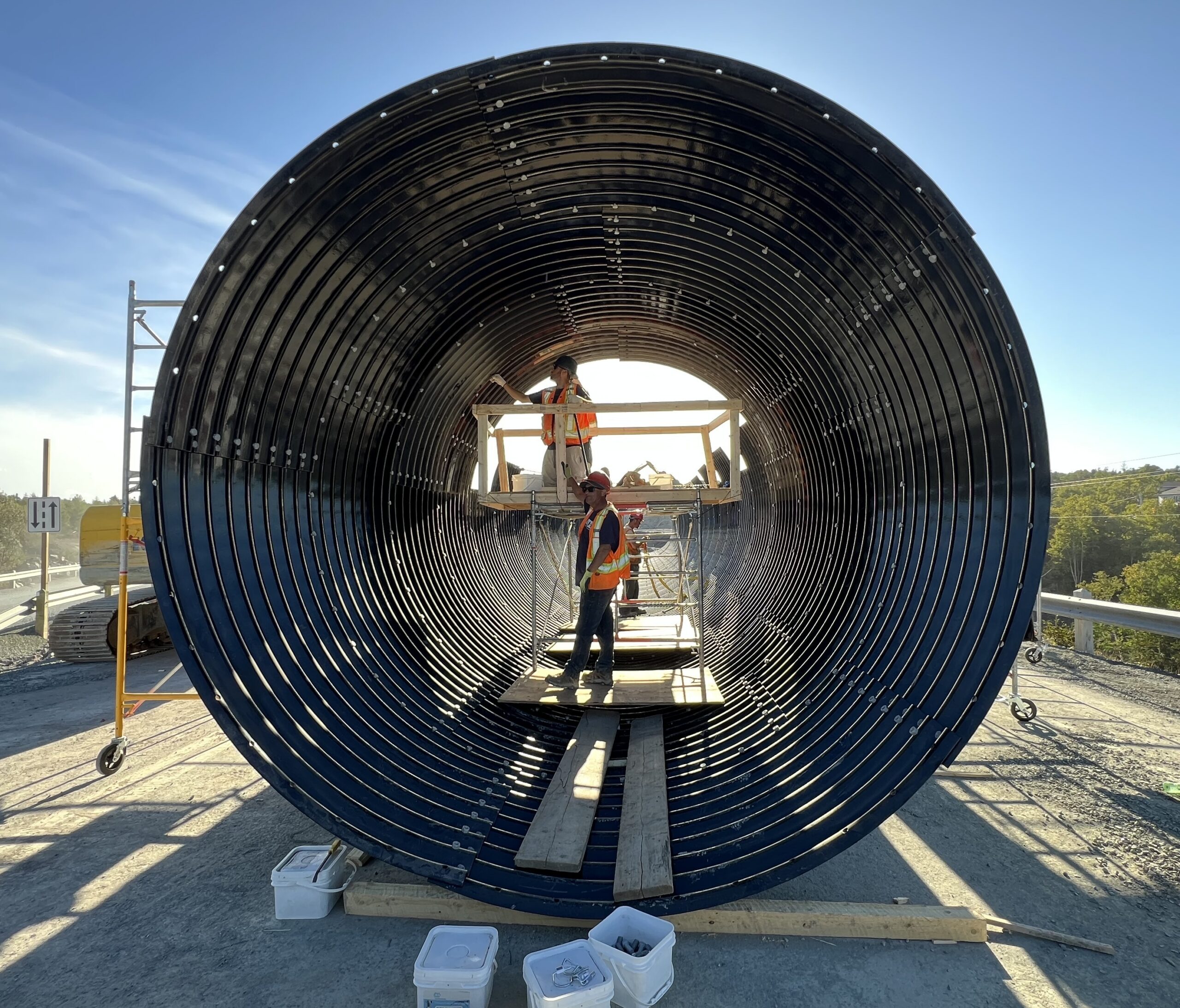 Front view of workers in safety vests and scaffolding in AIL Bolt-A-Plate round culvert